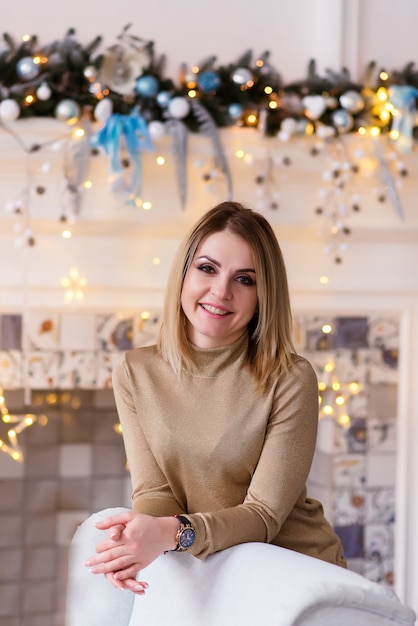 Belle femme près d'un arbre de Noël à la maison.