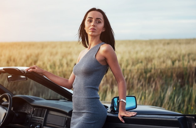 Belle femme près de cabriolet noir