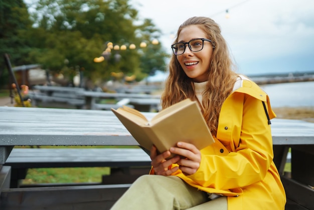 Une belle femme profite de l'air frais et lit un livre Concept de style de vie de relaxation