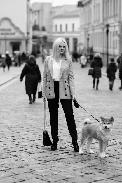 belle femme promener son chien dans la ville pendant la journée, akita, femme d'affaires.