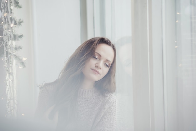 Belle femme en pull dormant et rêvant le jour de Noël