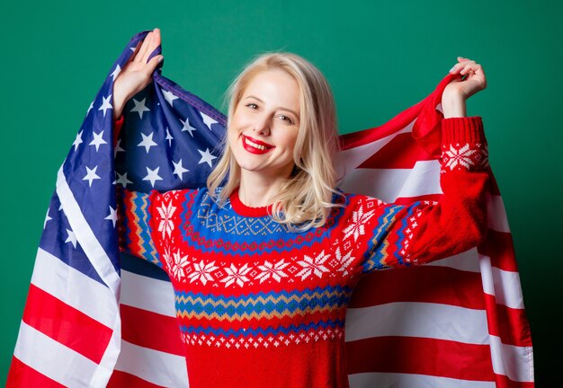 Belle femme en pull de Noël et drapeau USA