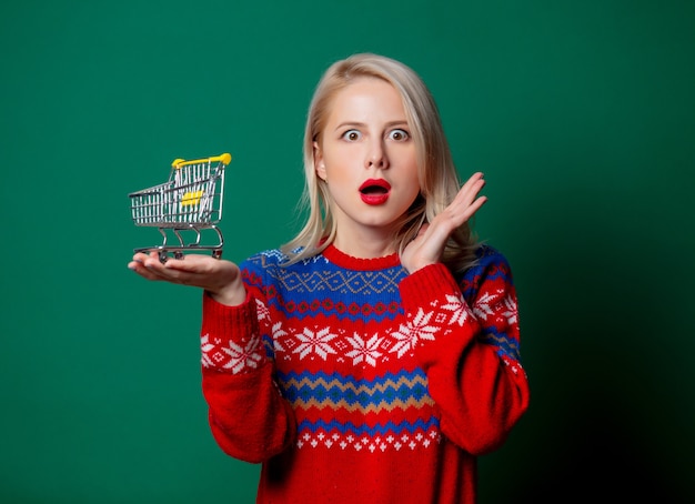 Belle femme en pull de Noël tient le panier