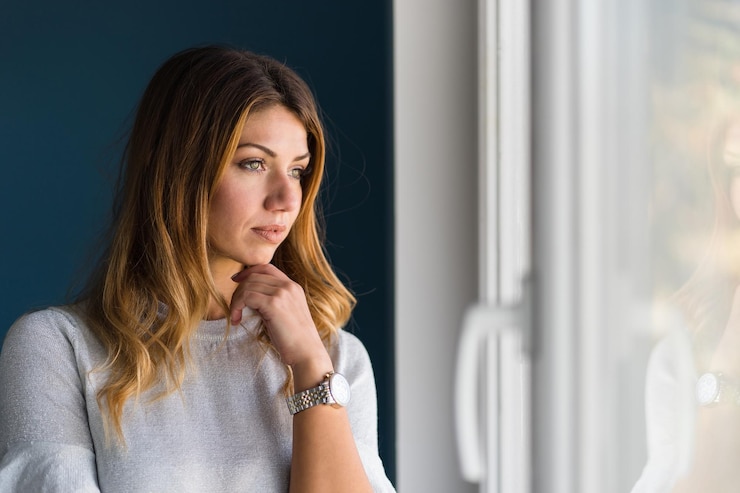 Photo une belle femme qui regarde par la fenêtre.