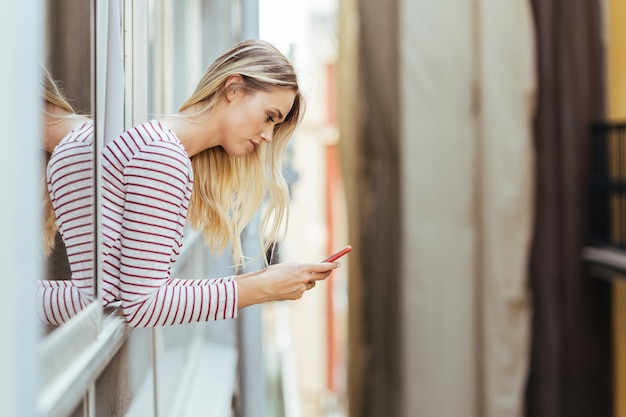 Photo une belle femme qui utilise un smartphone à la maison.