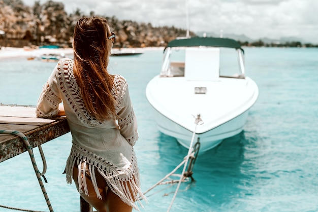 Photo belle femme de race blanche aux longs cheveux bruns en robe d'été profitant de la vue.