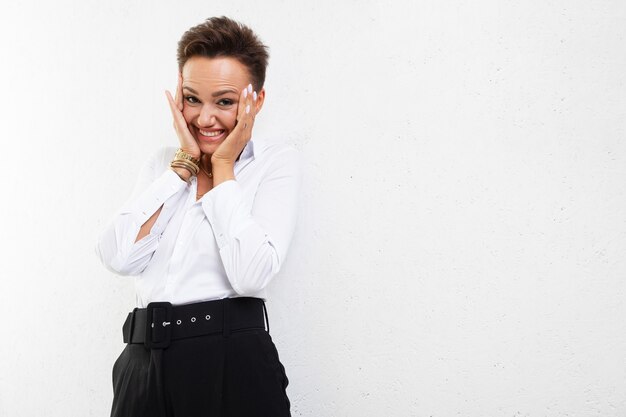 Belle femme de race blanche dans des vêtements de bureau sourit à la caméra