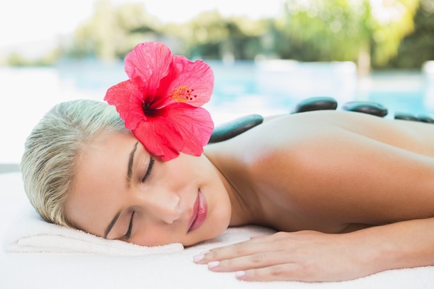 Belle femme recevant un massage aux pierres à la ferme de la santé