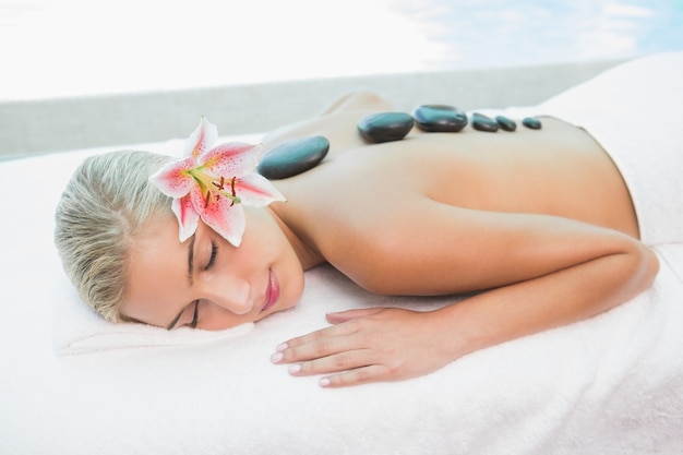 Belle femme recevant un massage aux pierres à la ferme de la santé