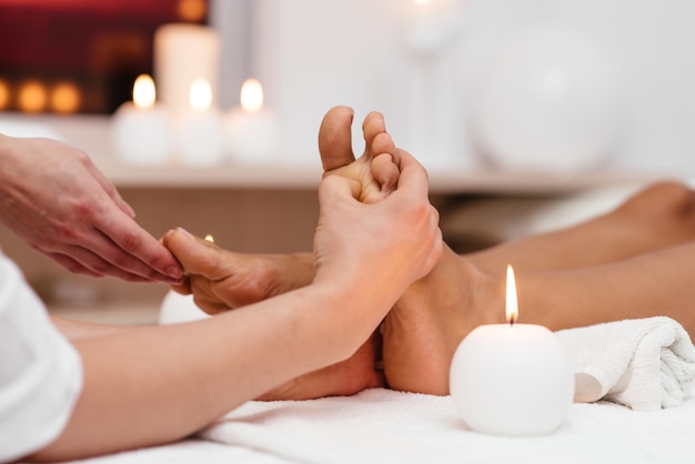 Belle femme recevant un massage des pieds dans le salon spa.