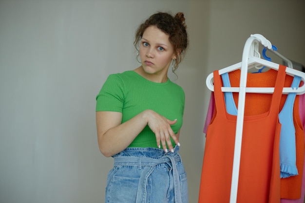 Belle femme repassage des vêtements sur un cintre garde-robe arrière-plans isolés inchangés