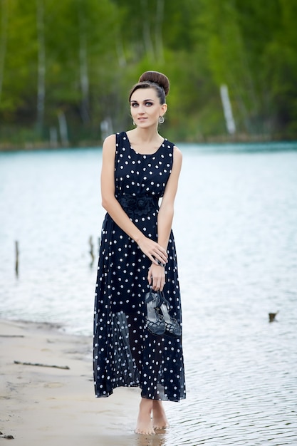 belle femme rétro dans des vêtements vintage au bord du lac