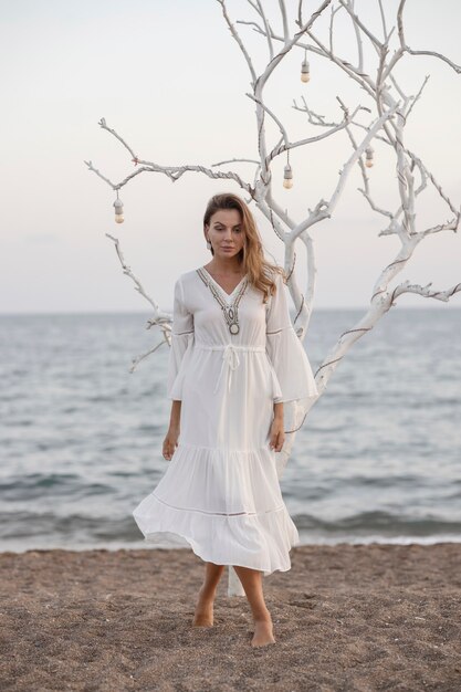 Belle femme en robe blanche au bord de la mer