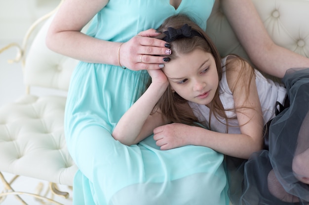 Belle femme en robe grecque marine avec fille sur les genoux