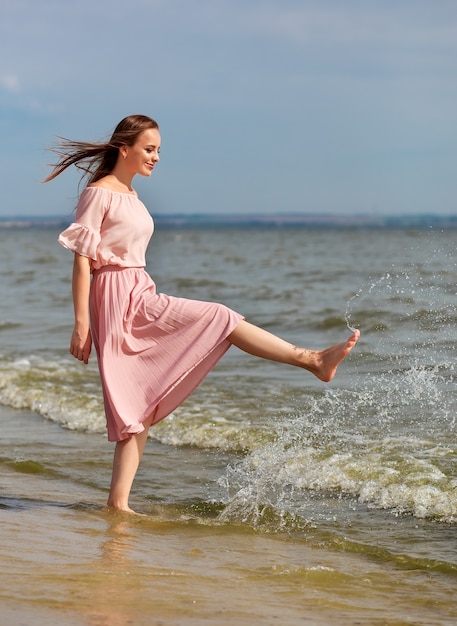 Belle femme en robe longue sur la plage