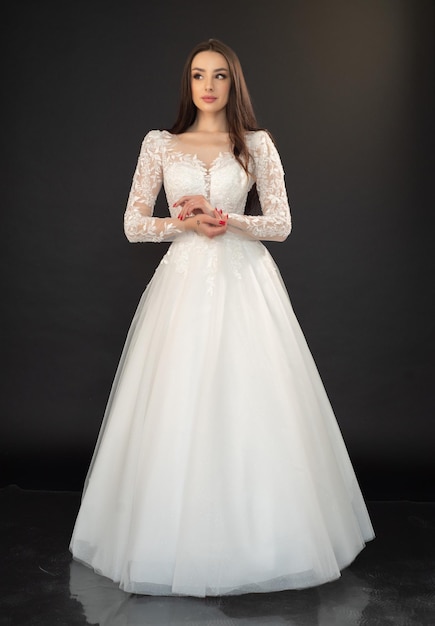 Belle femme en robe de mariée sur fond gris