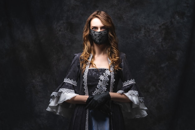 Belle femme en robe renaissance, masque facial et gants, coronavirus, concept de protection covid-19.