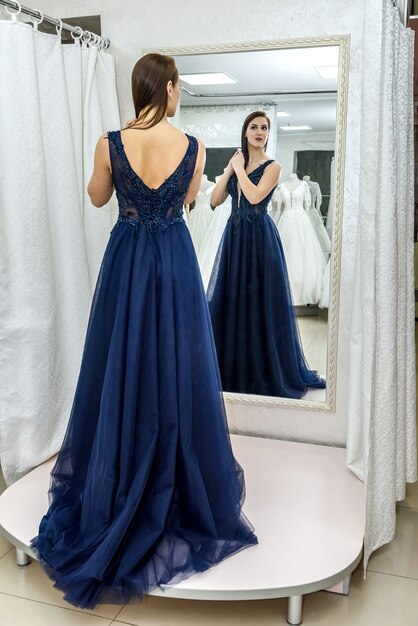 Belle femme en robe de soirée élégante posant pour la caméra