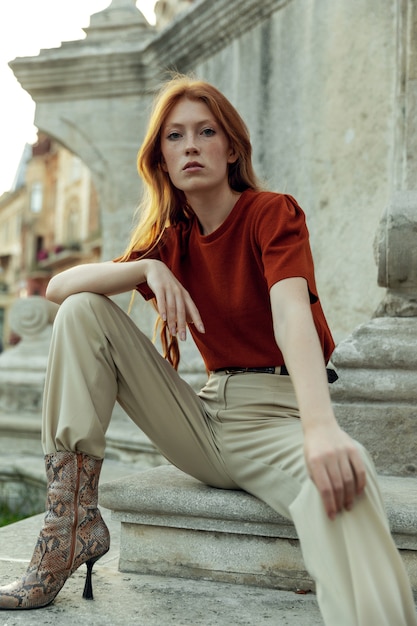 Photo belle femme rousse posant dans la rue