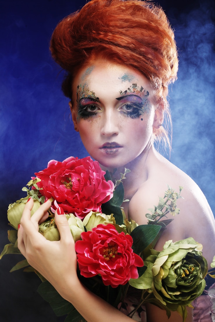 Photo belle femme rousse tenant des fleurs