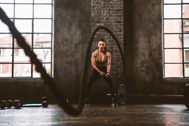 Photo belle femme s'entraînant et faisant un entraînement fonctionnel dans la salle de sport