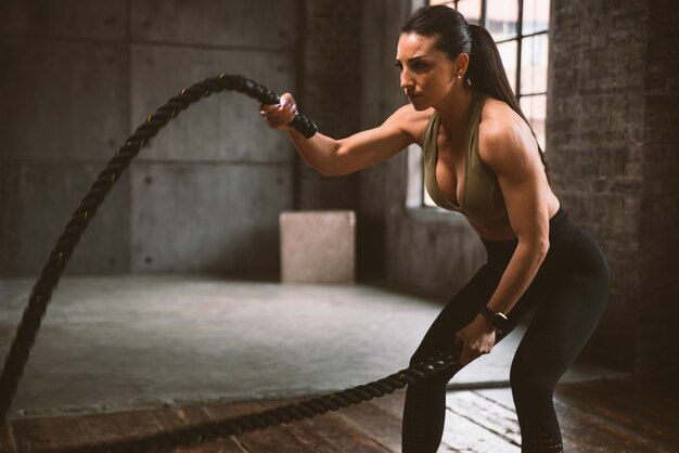 Belle femme s'entraînant et faisant un entraînement fonctionnel dans la salle de sport