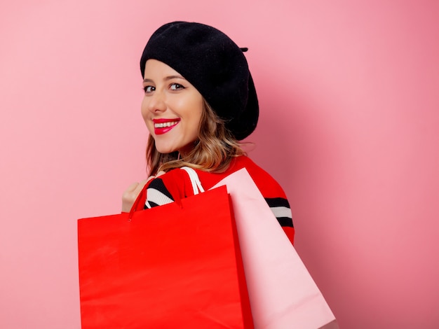 Belle femme avec des sacs sur le mur rose