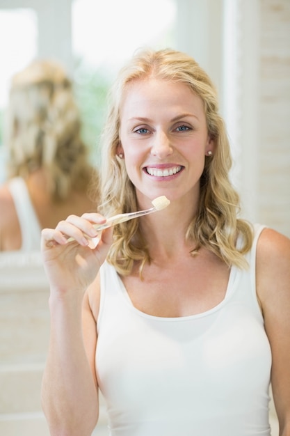 Belle femme se brosser les dents dans la salle de bain