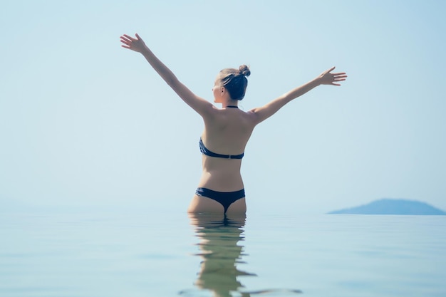 Belle femme se détend dans une piscine à débordement avec une vue imprenable sur les collines et la vallée des montagnes dans un hôtel écologique en Inde Goa Kerala wildernest nature resort summer happy day