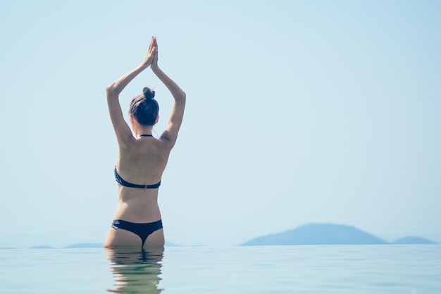 Belle femme se détend dans une piscine à débordement avec une vue imprenable sur les collines et la vallée des montagnes dans un hôtel écologique en Inde Goa Kerala wildernest nature resort summer happy day