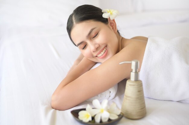 Une belle femme se détend et se fait masser dans la station thermale, concept de massage et de soins de beauté.