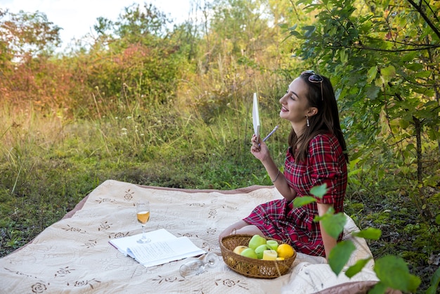 Belle femme se détendre dans la nature allongée sur une couverture et lire un livre. mode de vie