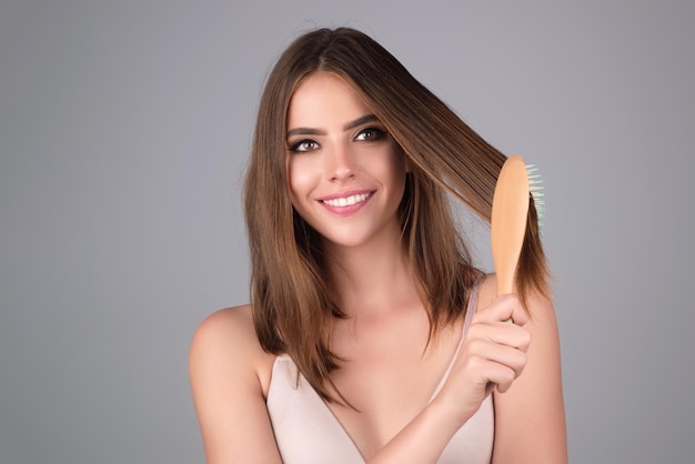 Une belle femme se peigne les cheveux en studio.