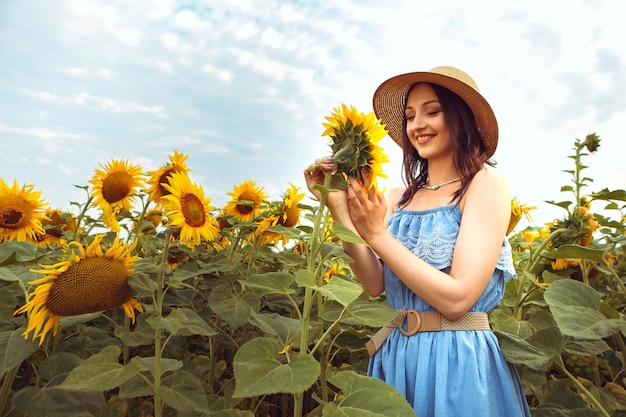 Belle femme se promène dans un champ de tournesol en fleurs bouquet jaune en plein air lever du soleil nature chaude