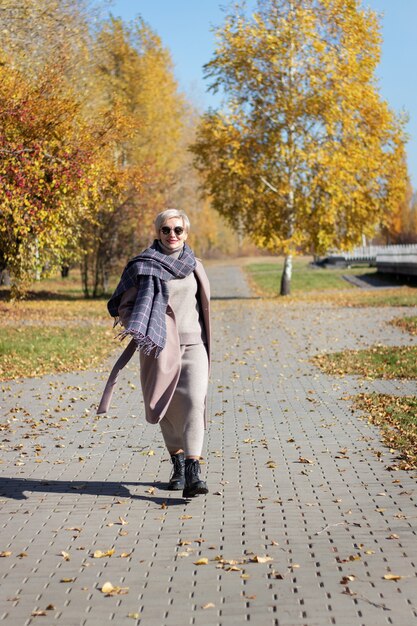 Belle femme se promène dans le parc en automne