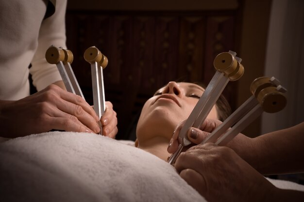 Belle femme sur séance d'acutonique de guérison sonore avec des diapasons