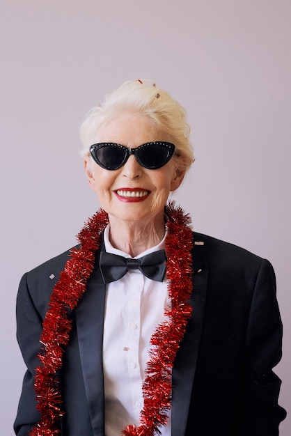 Belle femme senior mature élégante en lunettes de soleil et smoking célébrant le nouvel an
