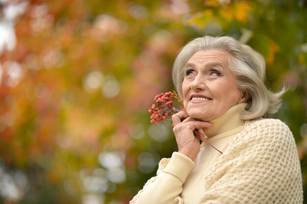 Belle femme senior posant à l'extérieur en automne