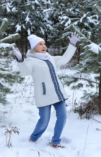 Belle femme senior posant à l'extérieur en hiver