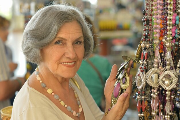 Belle femme senior souriante au magasin de souvenirs