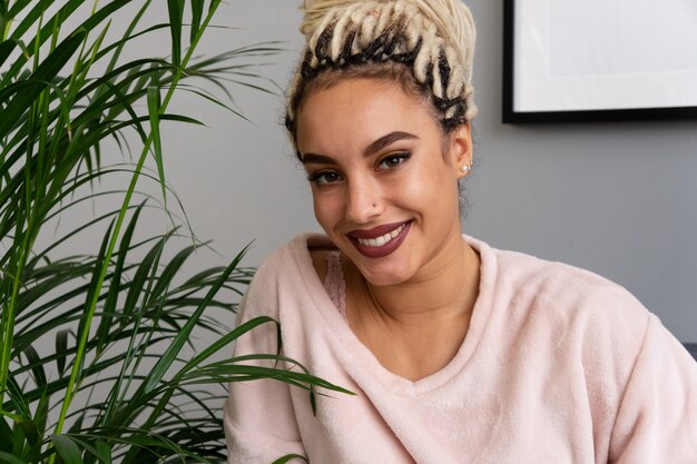 Belle Femme Sensuelle Souriant Près De Feuilles De Plante D'intérieur Dans La Chambre