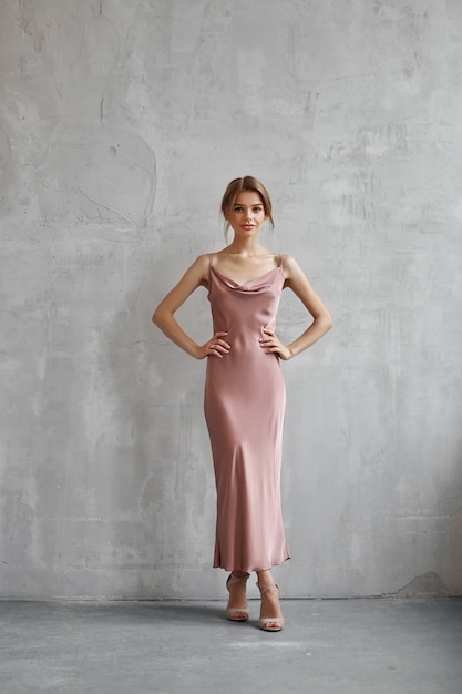 Belle femme sexy dans une robe en soie beige clair. Bruit, flou