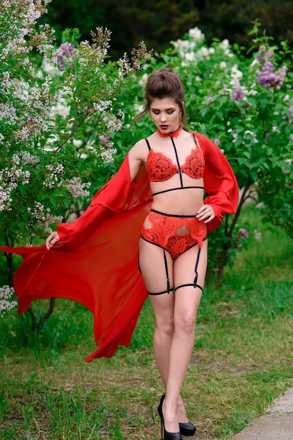 Belle femme sexy en lingerie rouge à l'extérieur