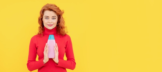 Belle femme avec un shampoing bio sur fond jaune clair