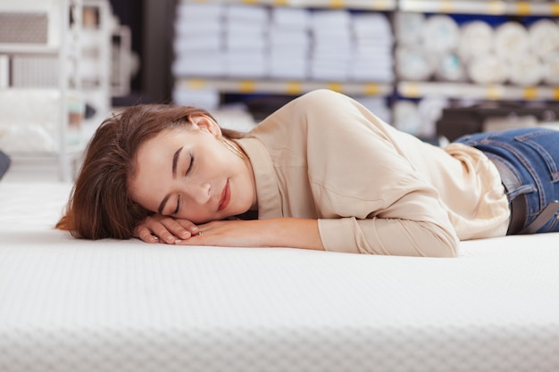 Belle femme shopping pour matelas orthopédique