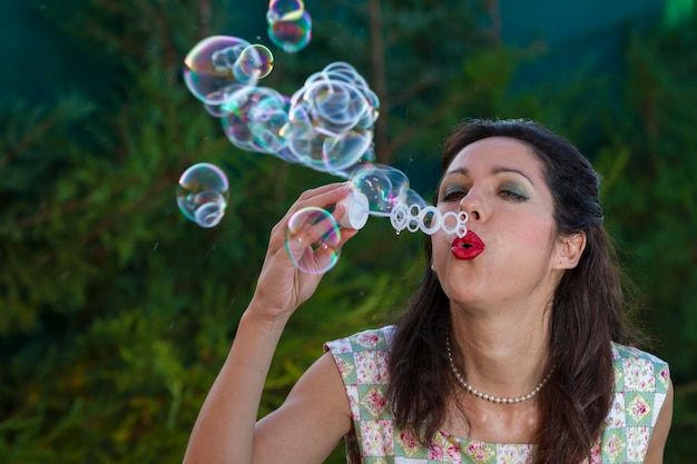 une belle femme soufflant des bulles. saison printanière, scène rurale