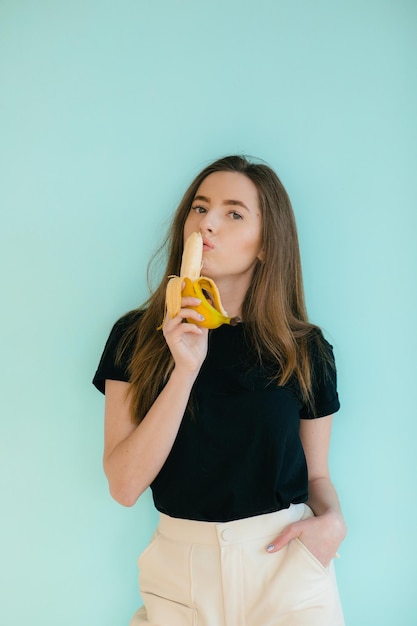 belle femme souriante avec banane près du visage