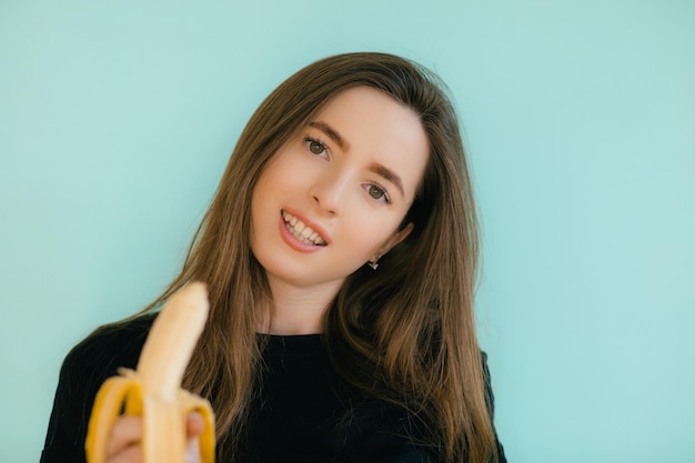 belle femme souriante avec banane près du visage