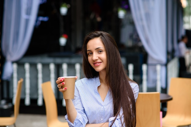 Belle femme souriante et buvant du café.