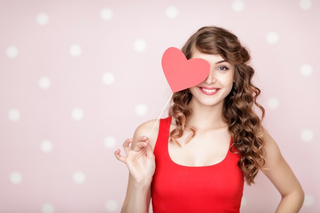 Belle femme souriante avec des coeurs rouges pour la Saint-Valentin